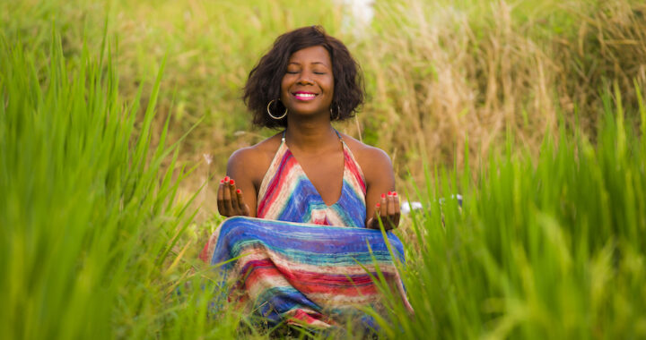 Smiling-Black-woman-in-a-field-meditating